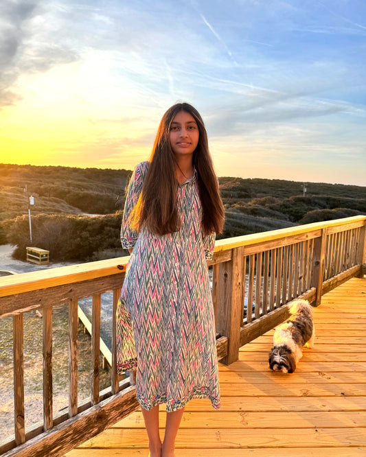 Harmony Dress – hand block-printed pink and green chevron cotton shirt dress with long sleeves, full-length front view at sunset